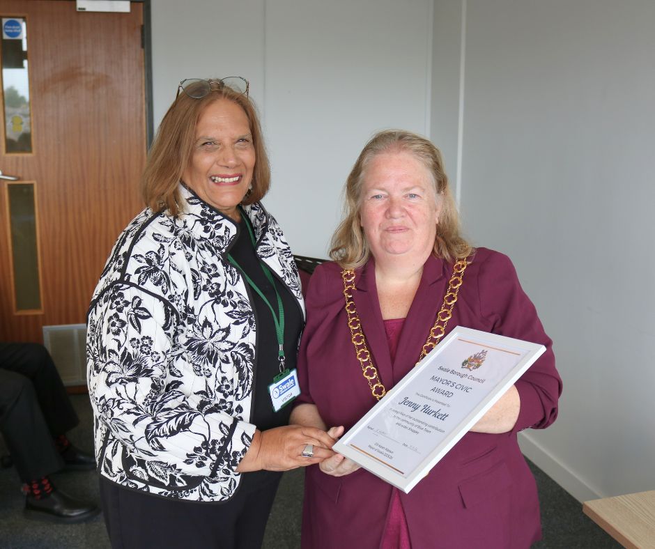 A woman receiving an award from the mayor