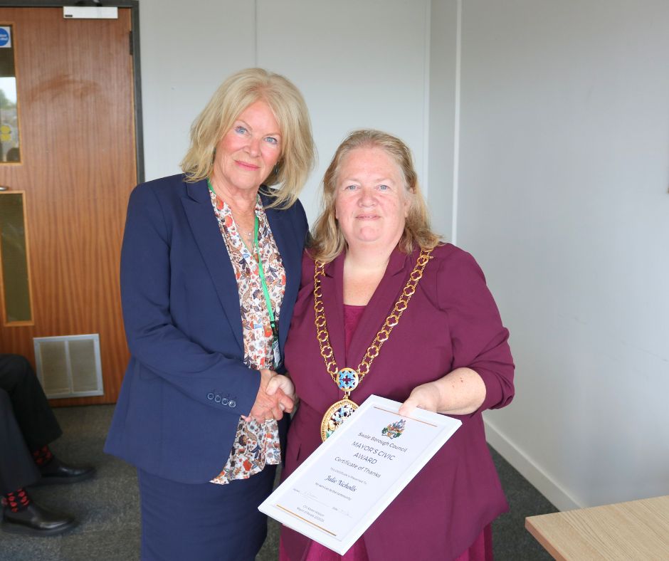 A woman receiving an award from the mayor