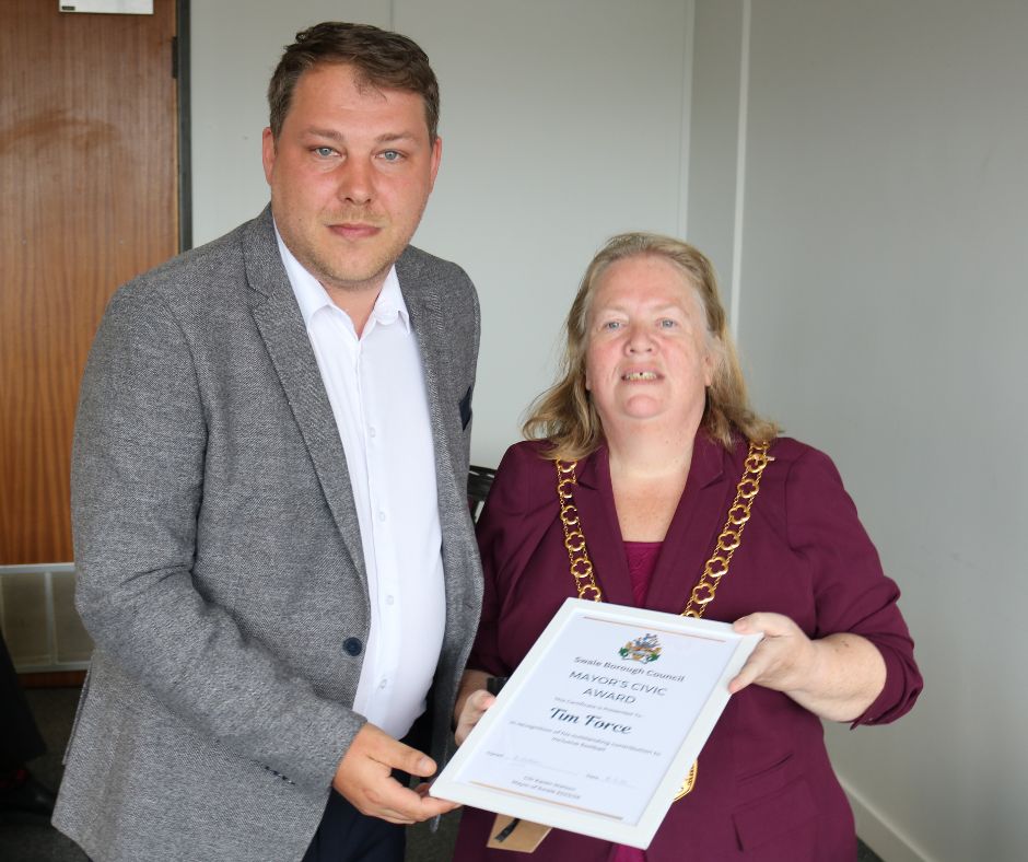 A man receiving an award from the mayor