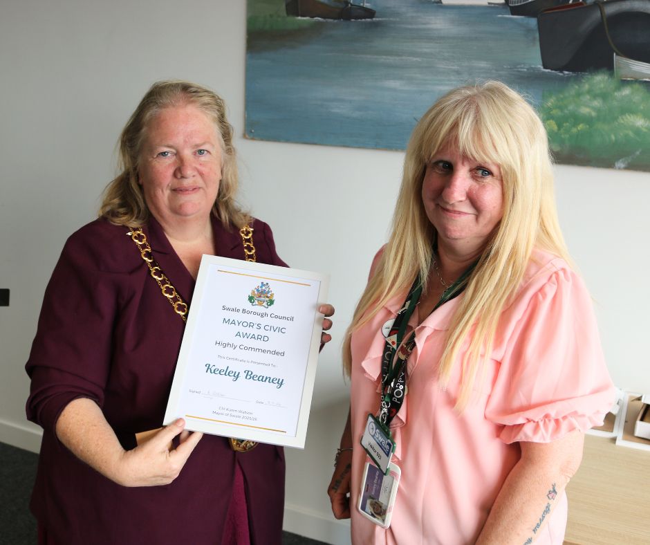 A woman receiving an award from the mayor
