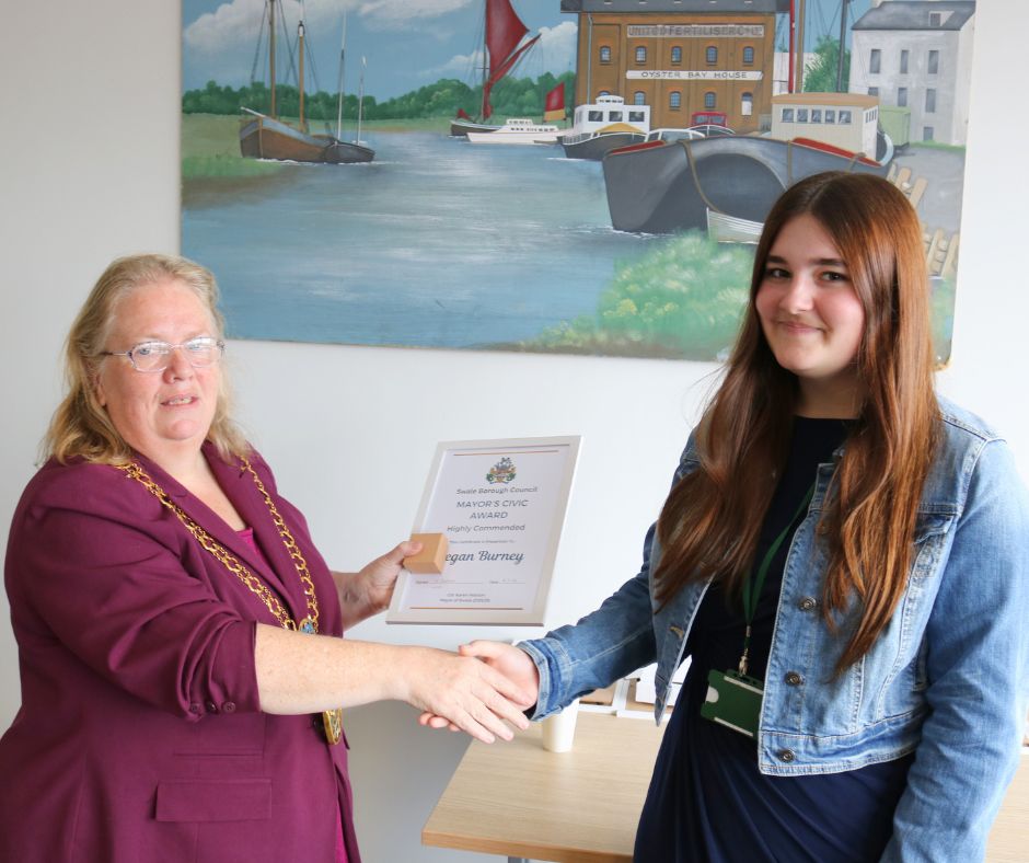 A woman receiving an award from the mayor