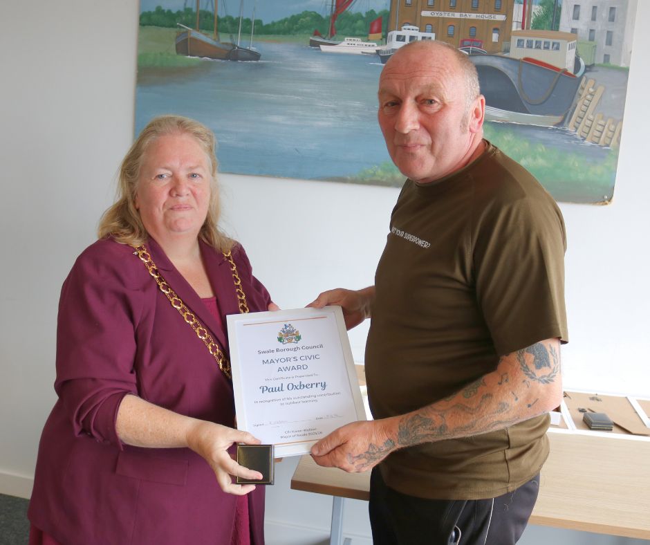 A man receiving an award from the mayor