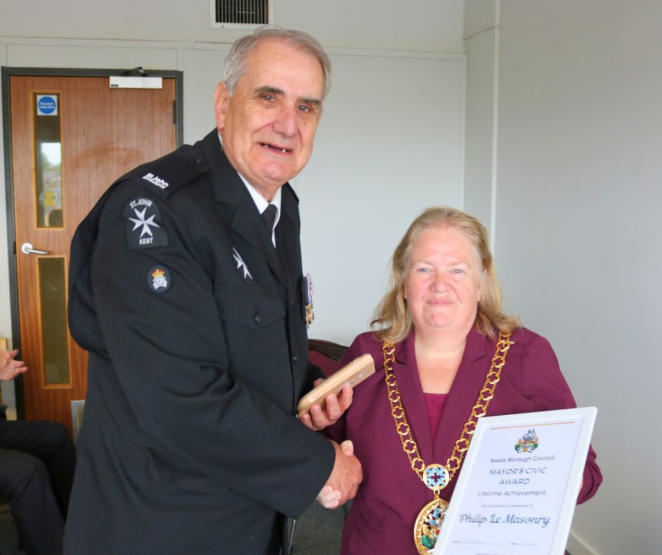 A man receiving an award from the mayor